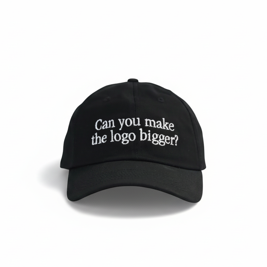 Black “Can you make the logo bigger?” embroidered dad hat on white background